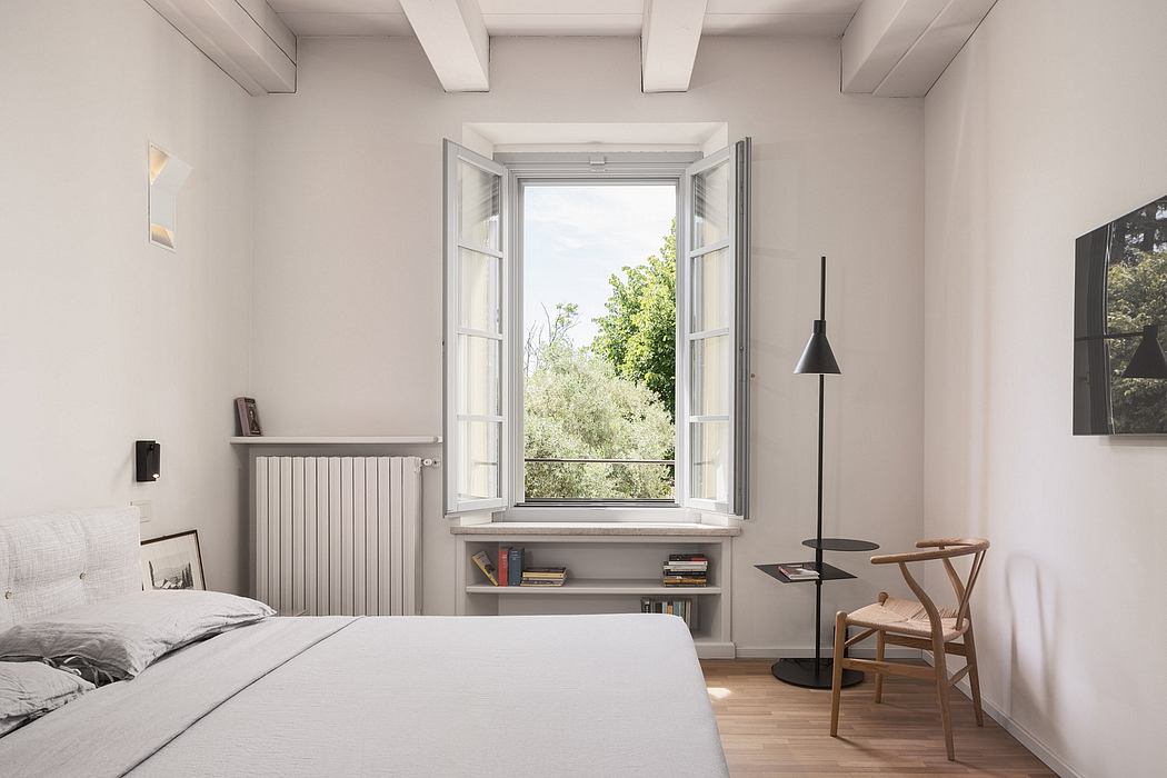 Airy bedroom with large window, shelving, and minimalist furnishings.