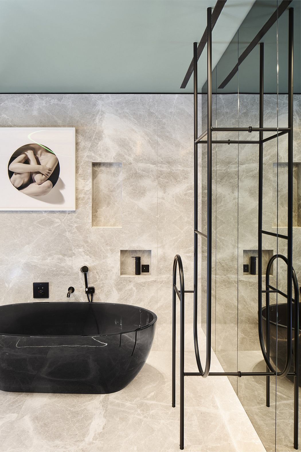A modern bathroom with sleek black fixtures, a freestanding tub, and minimalist artwork.