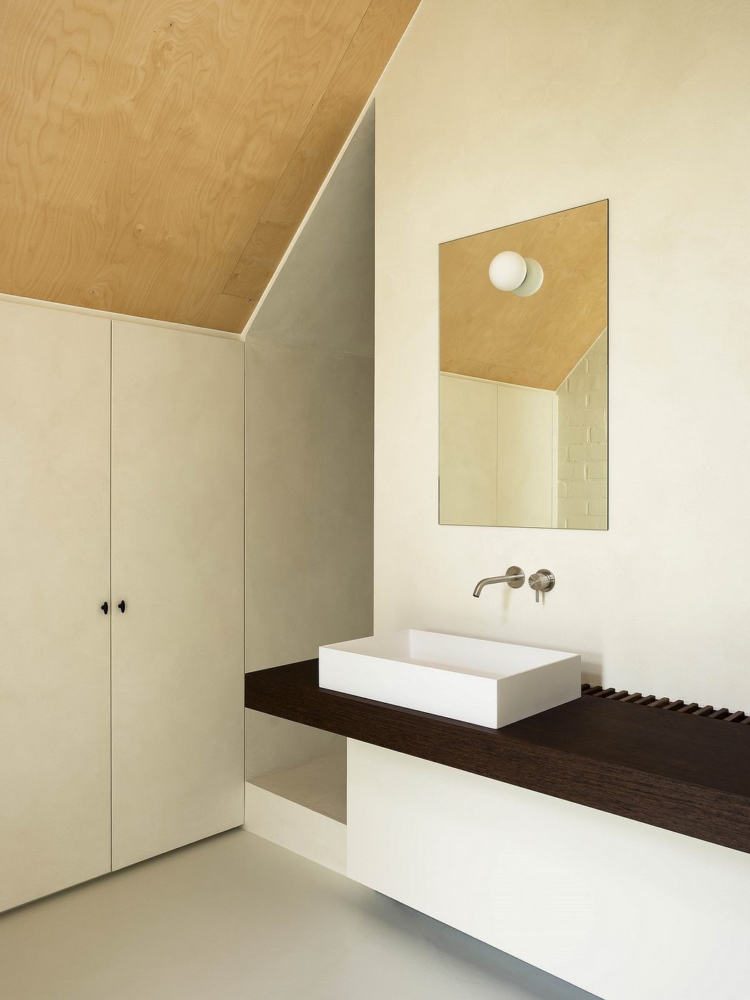 A minimalist bathroom design featuring a wooden ceiling, white walls, and a floating vanity with a vessel sink.