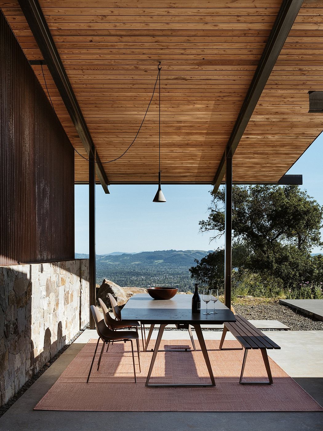 Rustic wooden ceiling, sleek modern furniture, and expansive views of nature.
