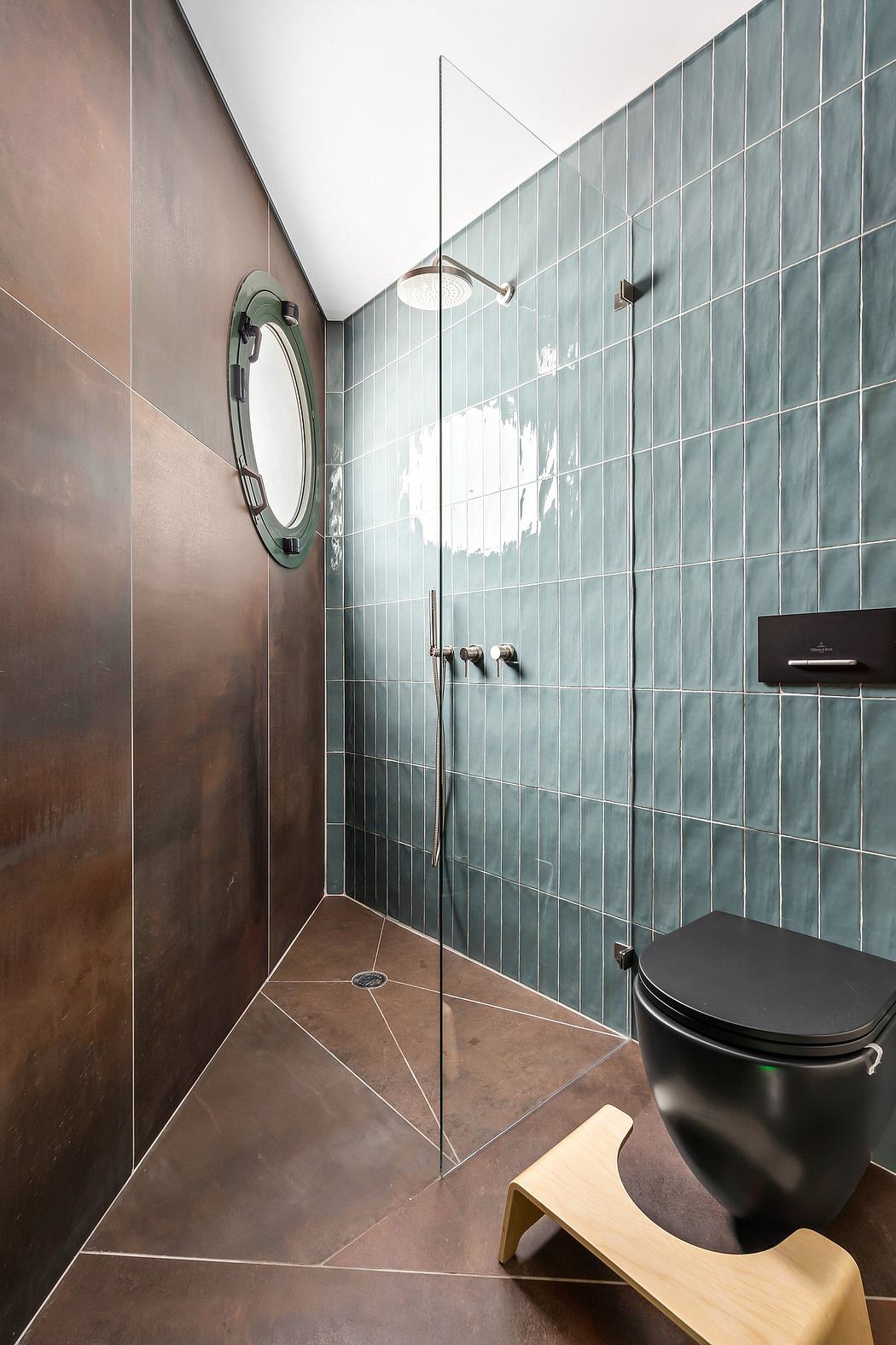 Sleek, modern bathroom with tiled walls, round mirror, and minimalist toilet design.