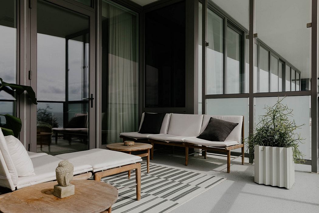 Sleek, modern patio with glass walls, plush seating, and wooden accents. Sophisticated outdoor space.