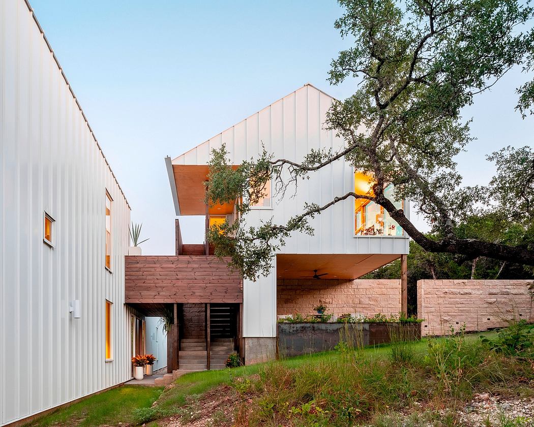 A modern, multi-level home with a striking angular design, blending seamlessly with the surrounding landscape.