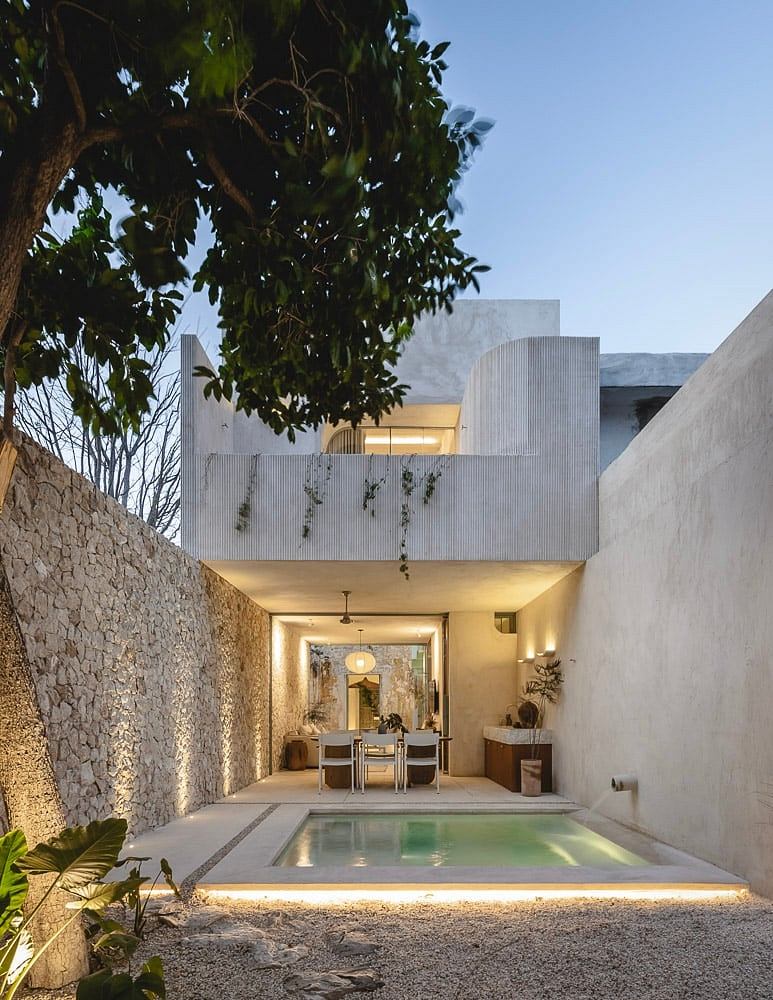 Modern minimalist architecture with a tranquil courtyard and pool, accented by foliage.