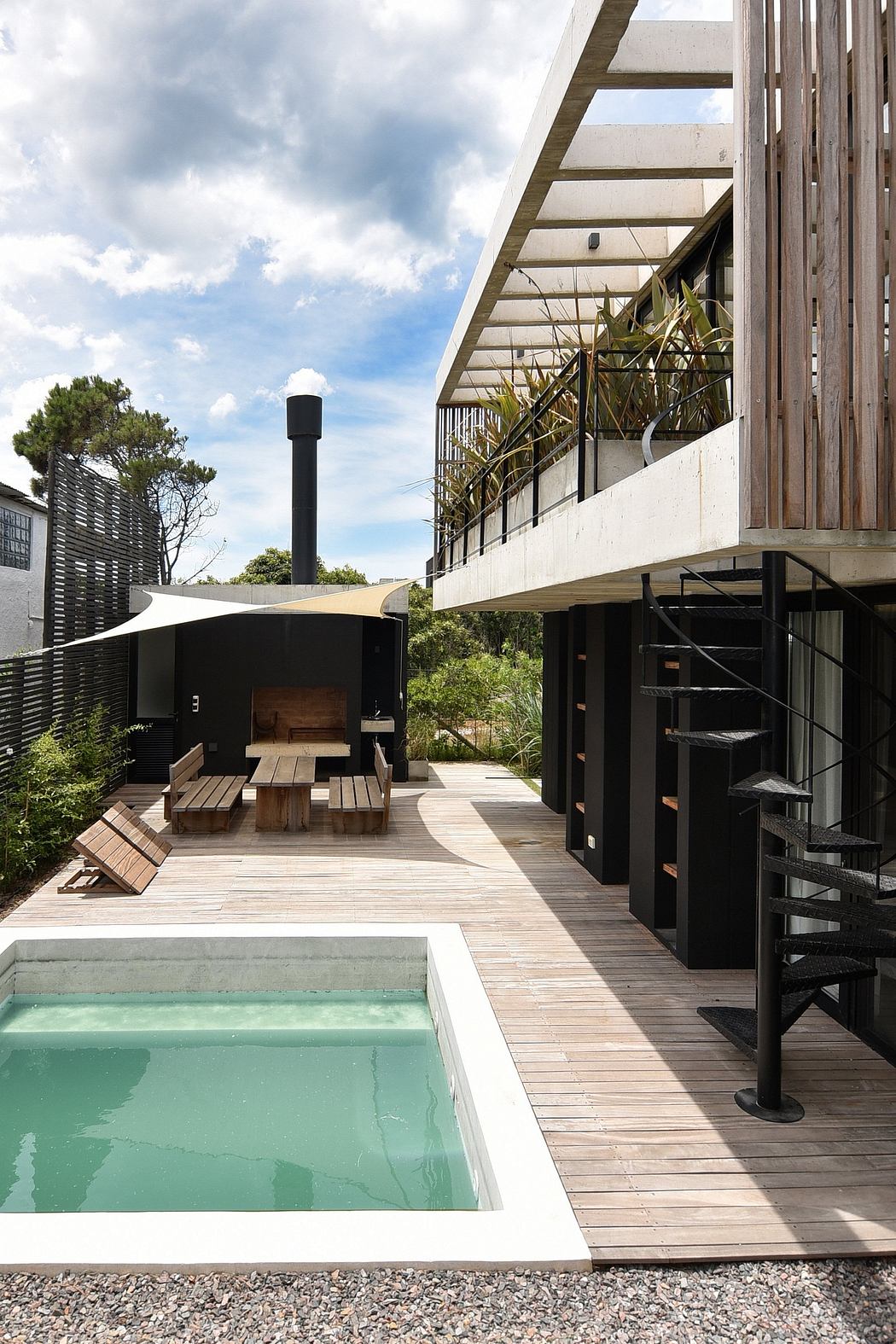 Modernist architectural elements, open-air deck, inviting pool, and lush, natural surroundings.