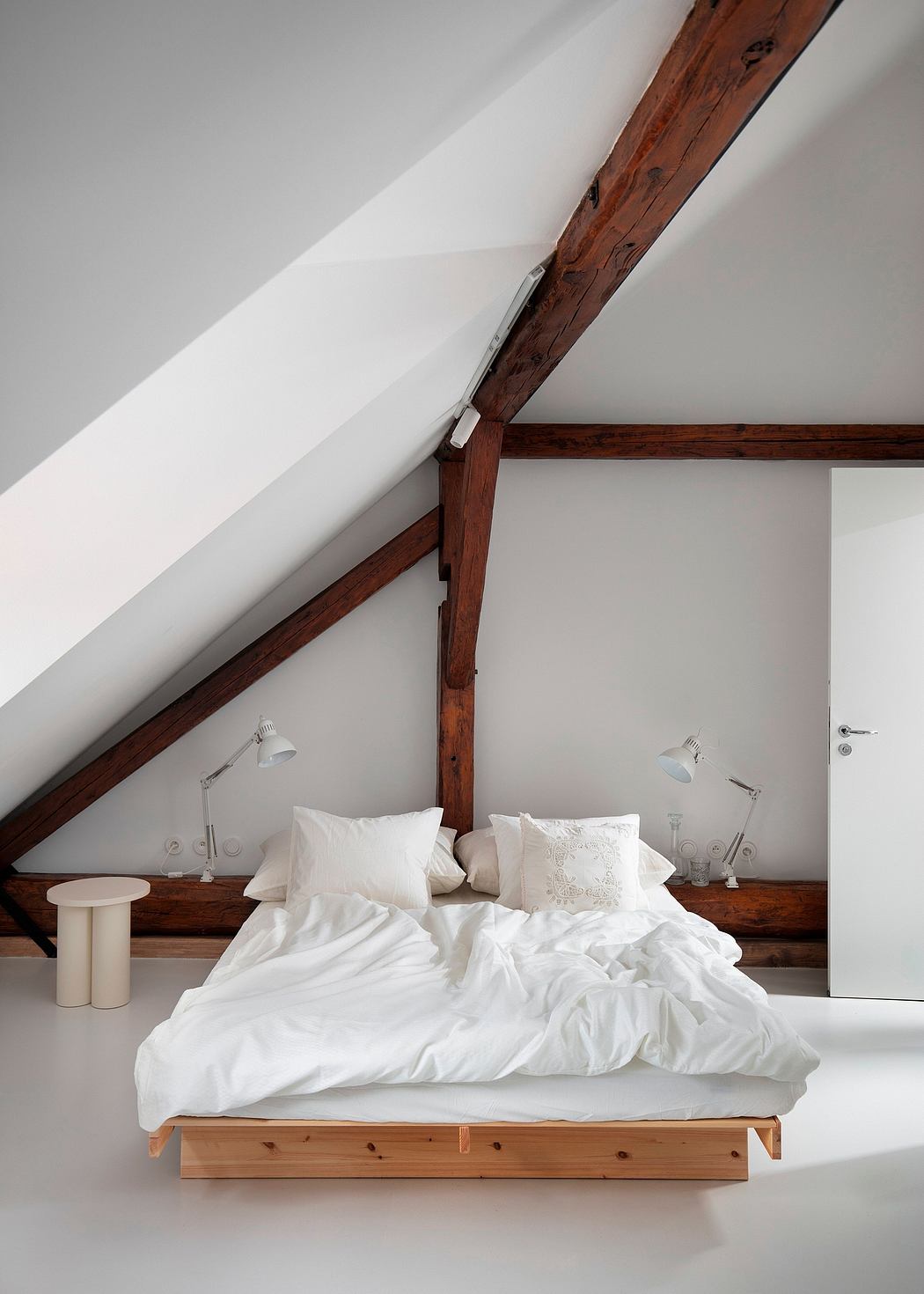 Cozy bedroom with rustic wooden beams, minimalist white bedding, and ambient lighting.