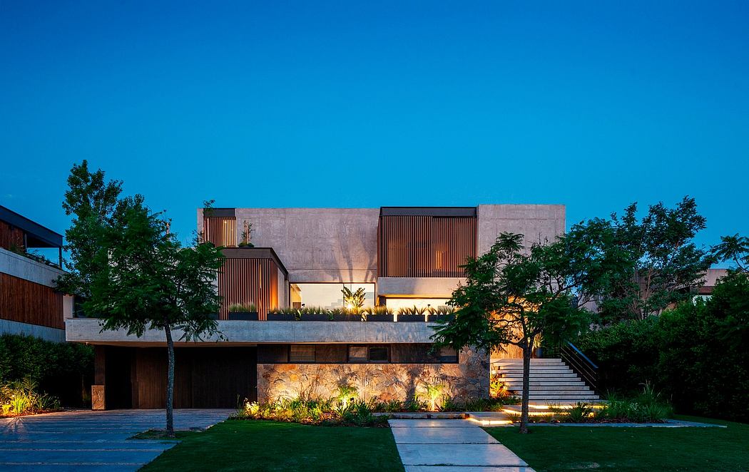 Sleek, modern architecture with striking concrete and wood elements, illuminated at night.