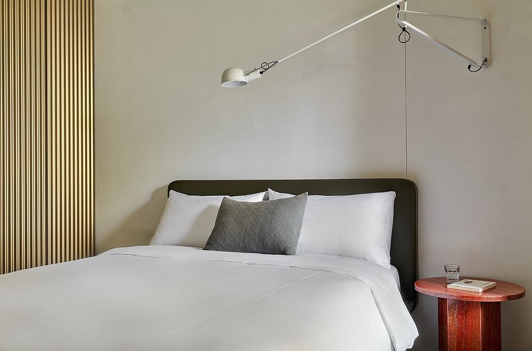 A minimalist bedroom with a modern, adjustable task lamp and clean-lined furnishings.