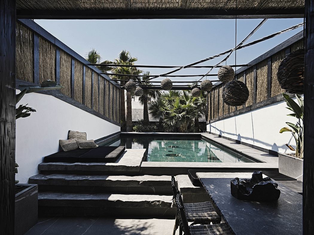 A serene outdoor patio with a sleek pool, stepping stones, and geometric architectural elements.