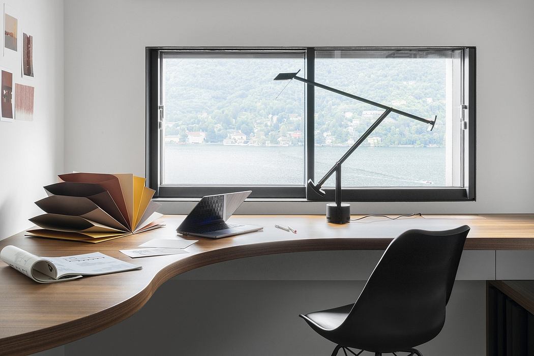 Elegant, modern home office with large window, wooden desk, and minimalist decor.