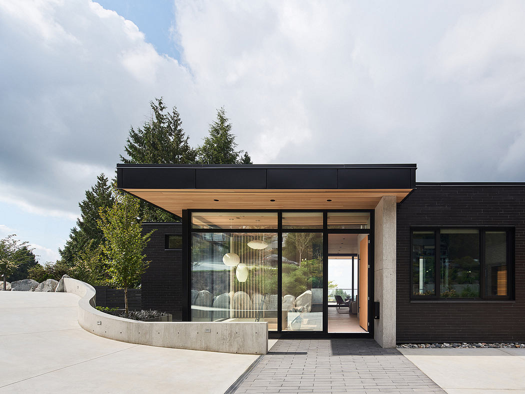 Striking modern architecture with wooden accents, glass walls, and a curvaceous concrete entrance.