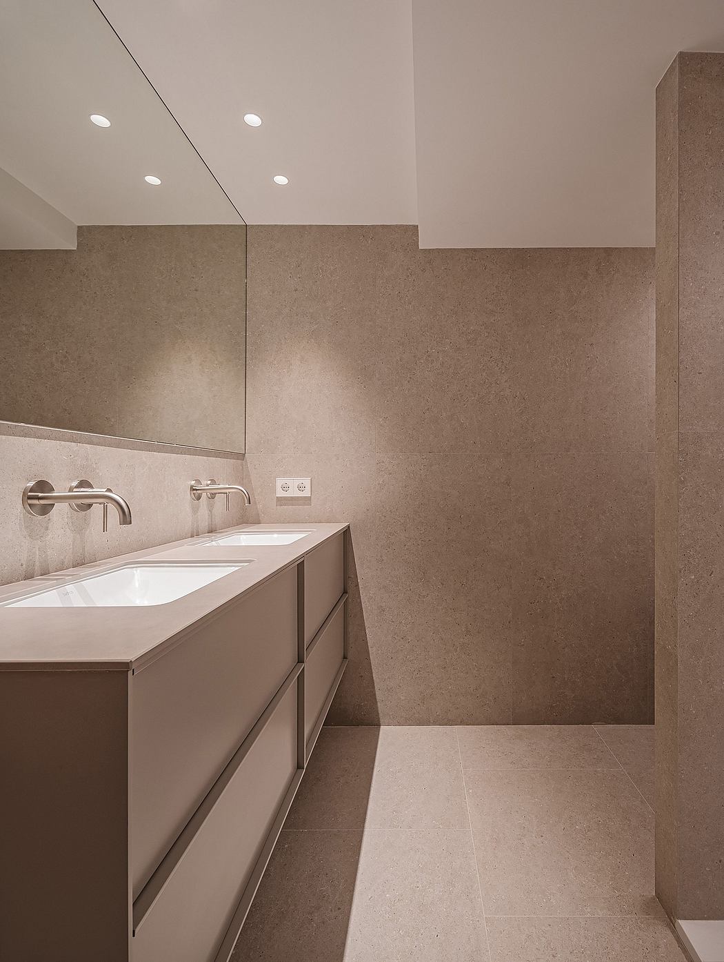 Minimalist bathroom design with recessed lighting, double vanity, and neutral tones.