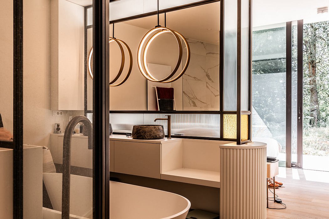 Modern bathroom with circular mirrors, marble vanity, and floor-to-ceiling windows providing natural light.