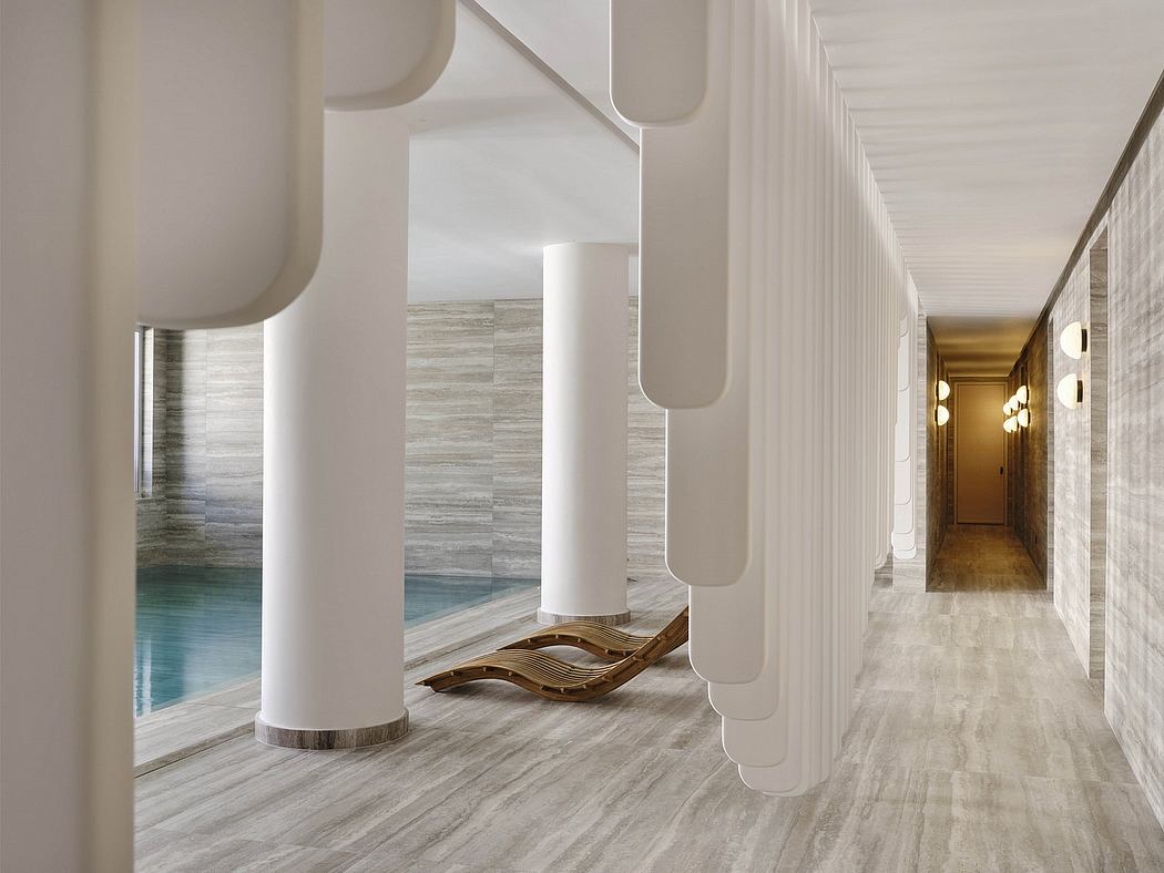 Elegant architectural hallway with curved columns, textured walls, and geometric lighting.