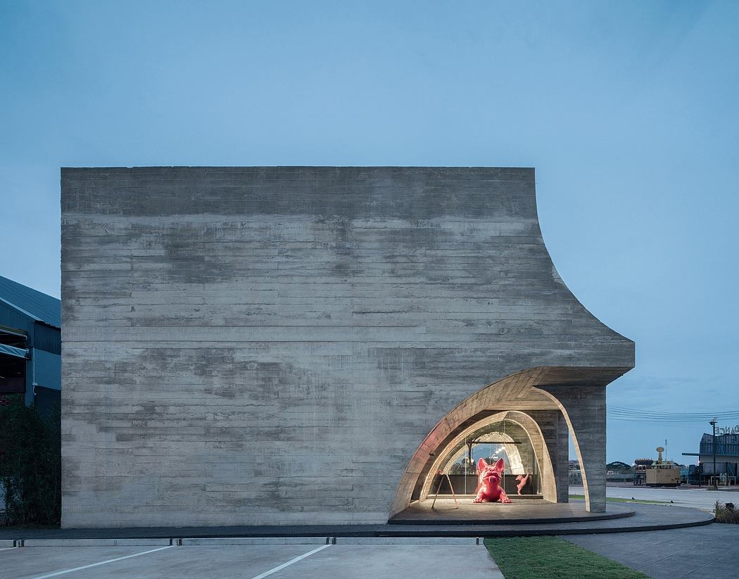 A large concrete structure with a recessed wooden pavilion, set against a blue sky.