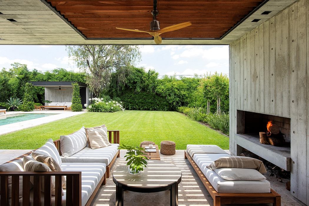 Spacious outdoor living area with rustic wood accents, comfortable seating, and fireplace.