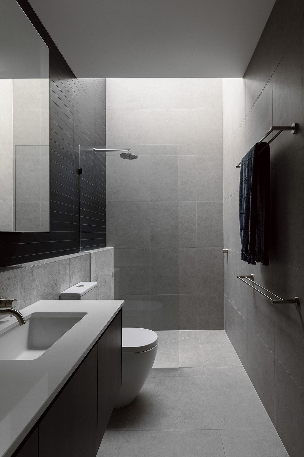 A modern, minimalist bathroom with clean lines, a glass shower enclosure, and sleek fixtures.