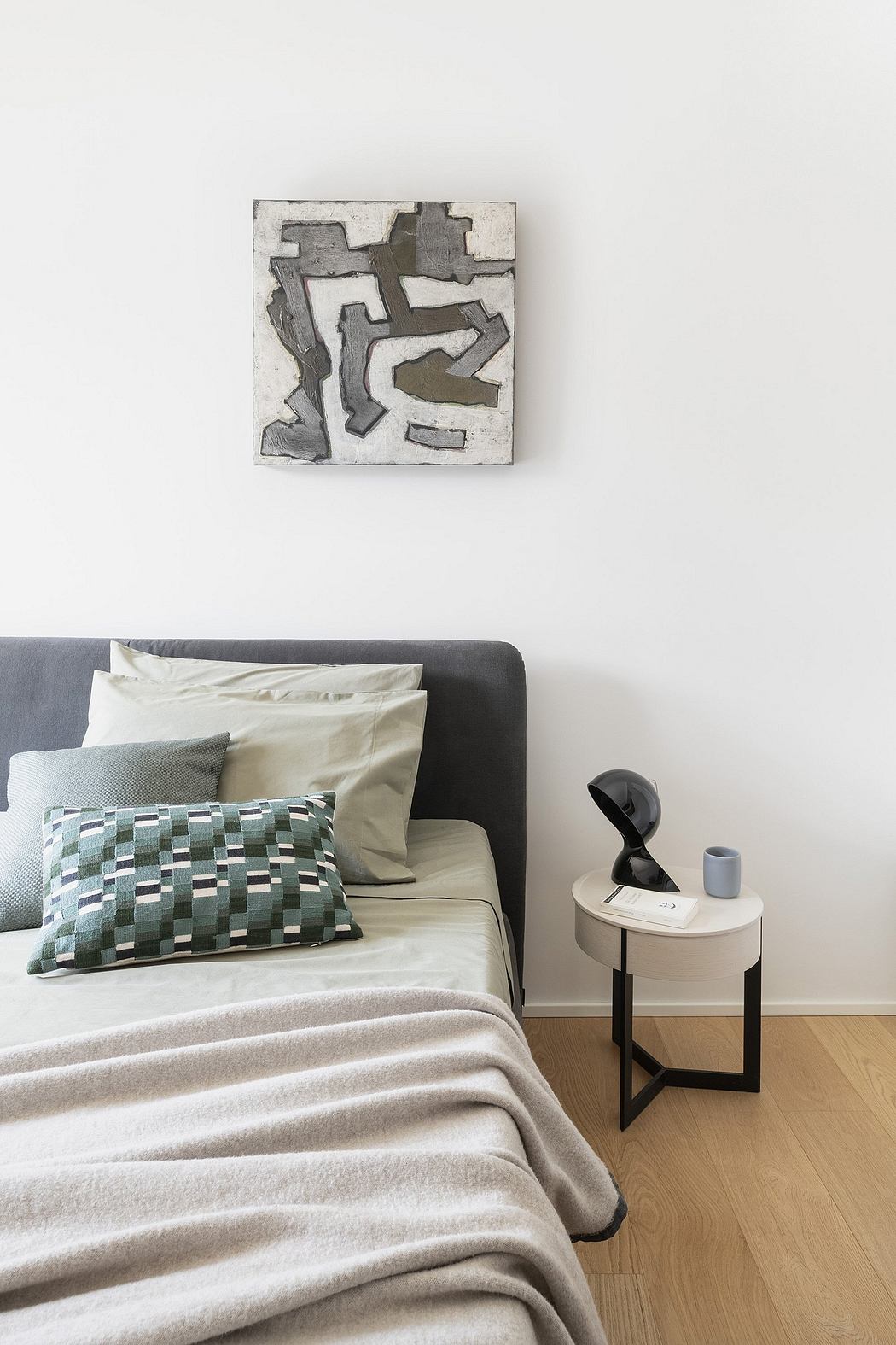 Minimalist bedroom design with abstract artwork, modern furniture, and soft textures.