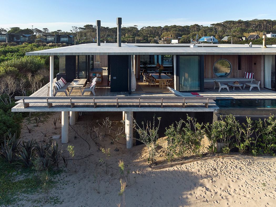 A modern beachfront home with an open floor plan, elevated deck, and panoramic views.