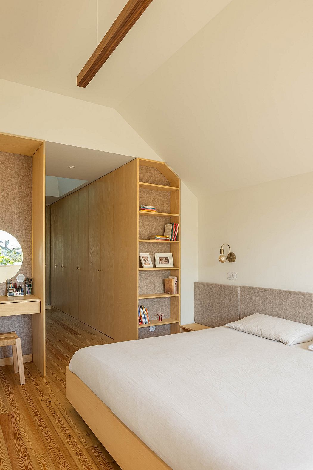 A modern bedroom interior with wooden beams, built-in cabinetry, and hardwood floors.