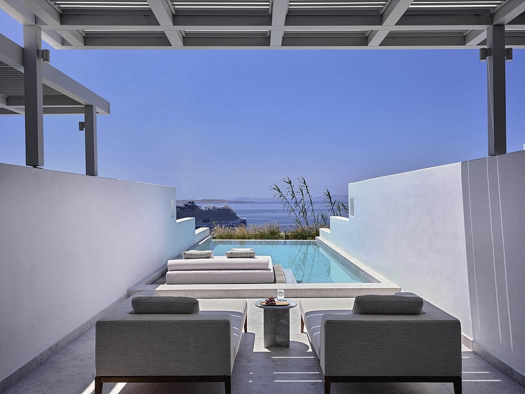 Sleek, modern terrace with infinity pool, lounge chairs, and panoramic sea views.