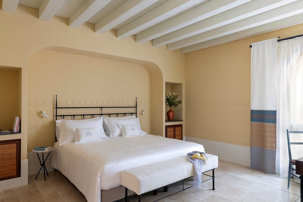 Spacious bedroom with white beams, arches, and neutral-toned decor creates a cozy ambiance.