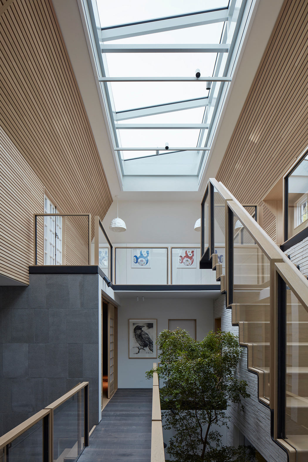 Spacious modern interior with wooden paneling, glass skylight, and decorative artwork.