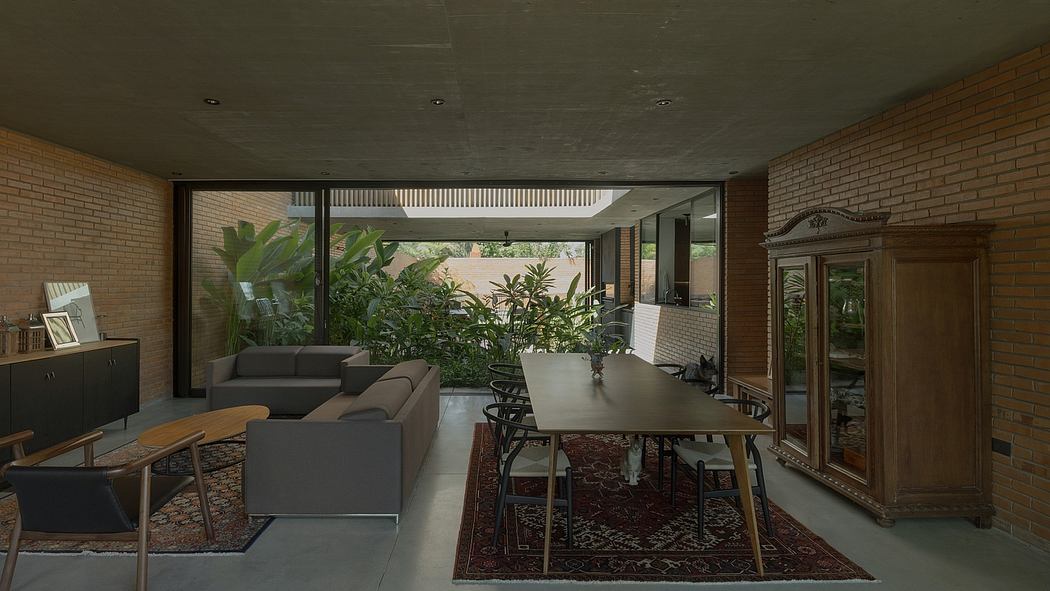 Expansive interior with brick walls, glass partition, lush greenery, and a dining area.