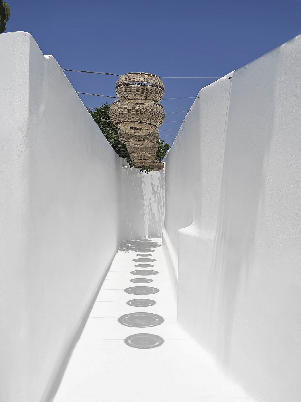 Architectural wonder showcasing unique woven light fixtures suspended above a minimalist walkway.