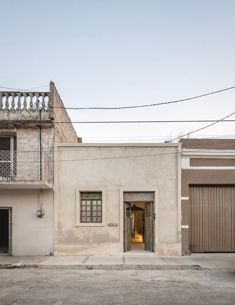 A weathered facade with simple entrances, suggesting a modest urban residential building.