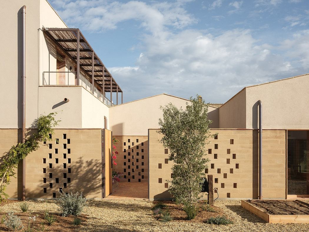 Striking architectural design featuring wooden stairs, perforated walls, and lush greenery.