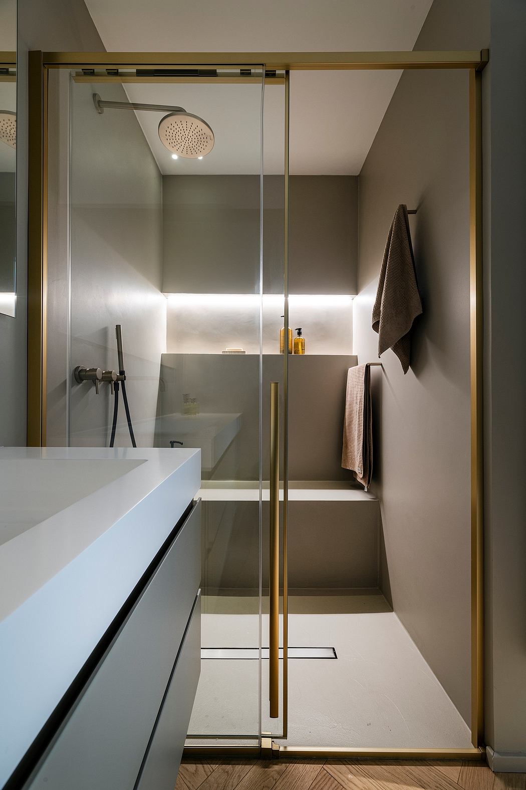 Minimalist bathroom design with glass-enclosed shower and sleek vanity.