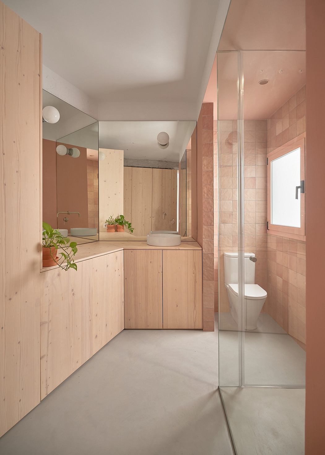 A modern bathroom with wood paneling, a vessel sink, and a glass shower enclosure.