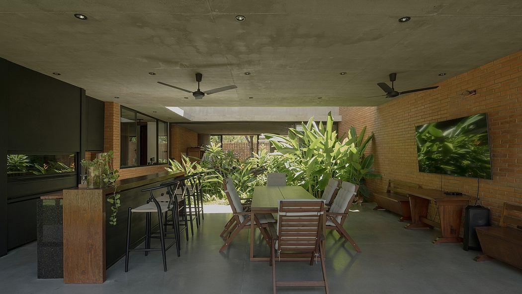 An open-concept indoor-outdoor dining area with a lush jungle-like atmosphere.