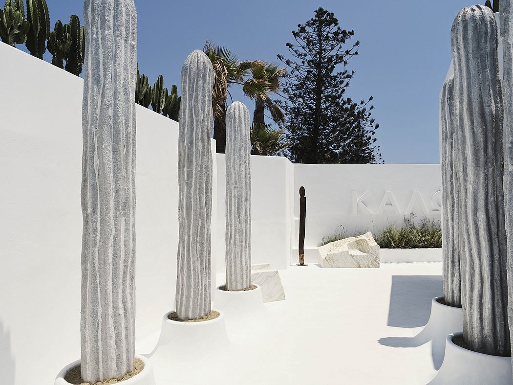 Striking modern architectural design featuring tall stone sculptures and cacti.