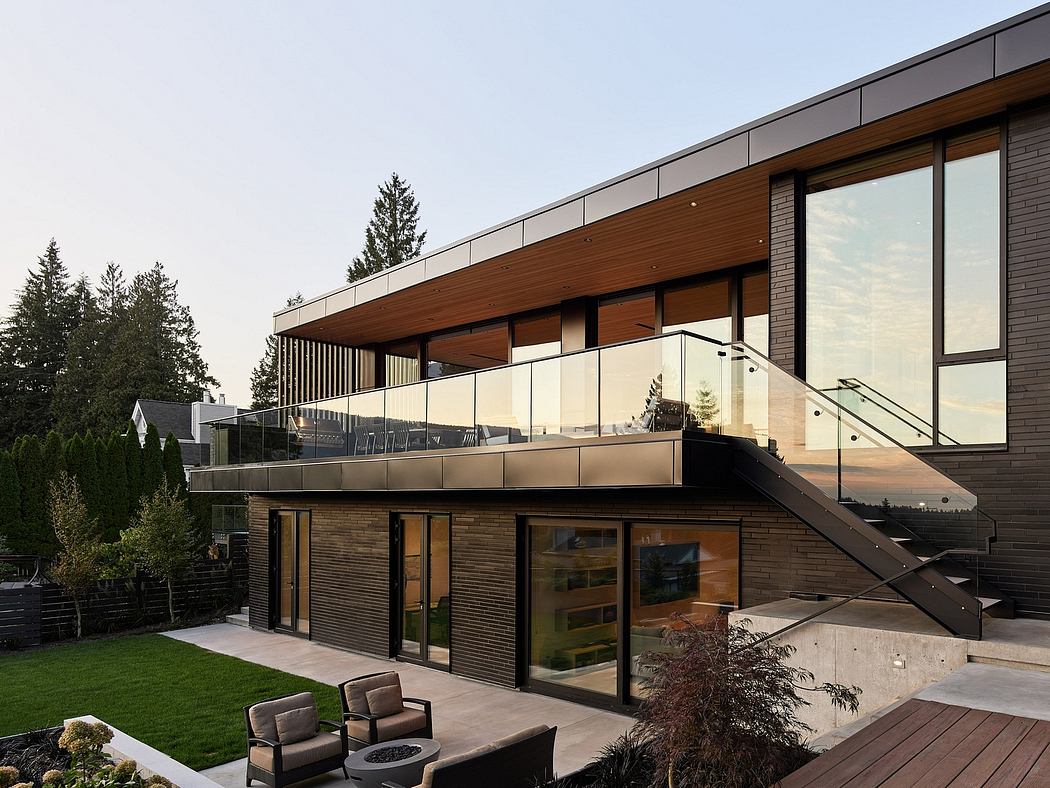 A modern, sleek house with wooden and glass exterior, balcony, and landscaped yard.