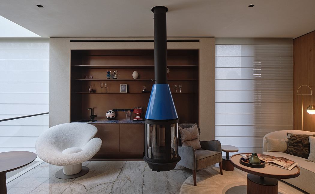Sleek, minimalist living room with cozy furniture, built-in shelving, and a striking freestanding fireplace.
