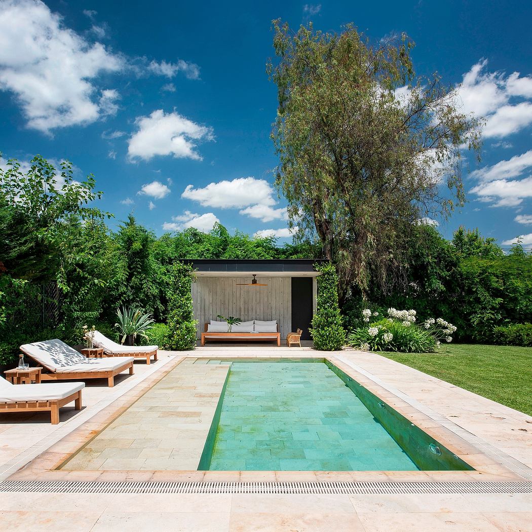 Serene backyard oasis with a sleek pool, wooden decking, and lush greenery.
