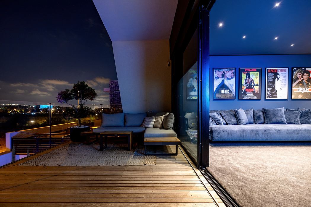 Cozy outdoor lounge area with movie posters, modern decor, and illuminating night view.