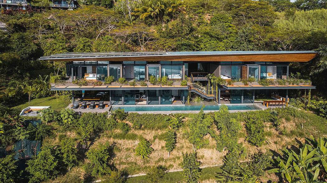 A modern, multi-level vacation home nestled in lush, tropical greenery with an expansive pool.
