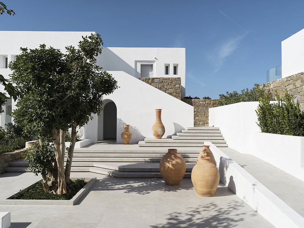 Minimalist Mediterranean architecture with ornate pottery and lush greenery.