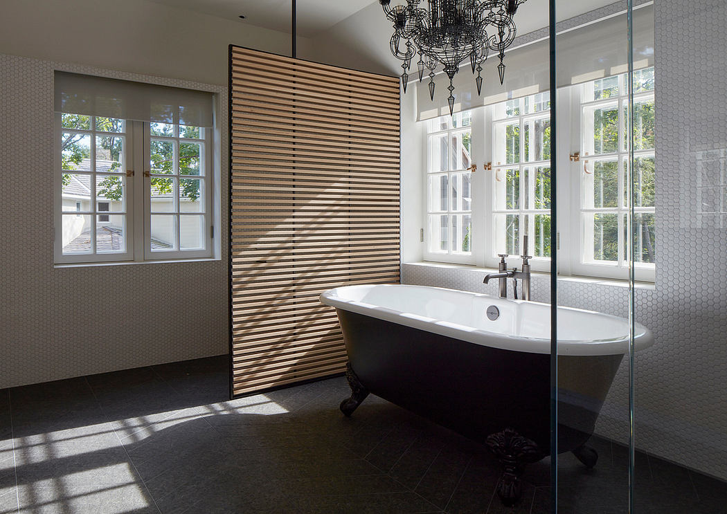 Elegant bathroom with freestanding tub, wood paneling, and sophisticated chandelier.