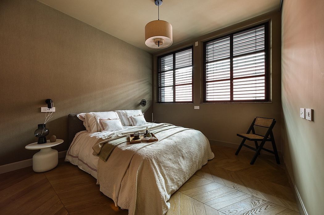 Cozy bedroom with warm beige walls, wooden floors, and a large window providing natural light.