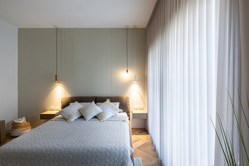 A cozy bedroom with a large bed, pendant lights, and floor-to-ceiling curtains.