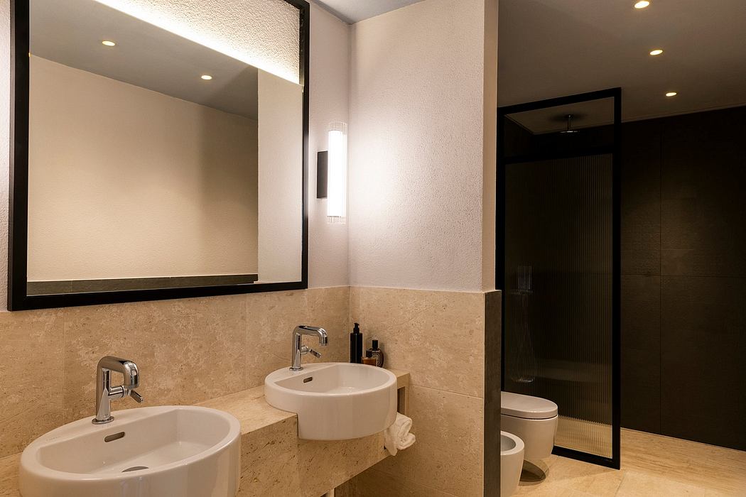 A modern, minimalist bathroom with dual sinks, a large mirror, and recessed lighting.
