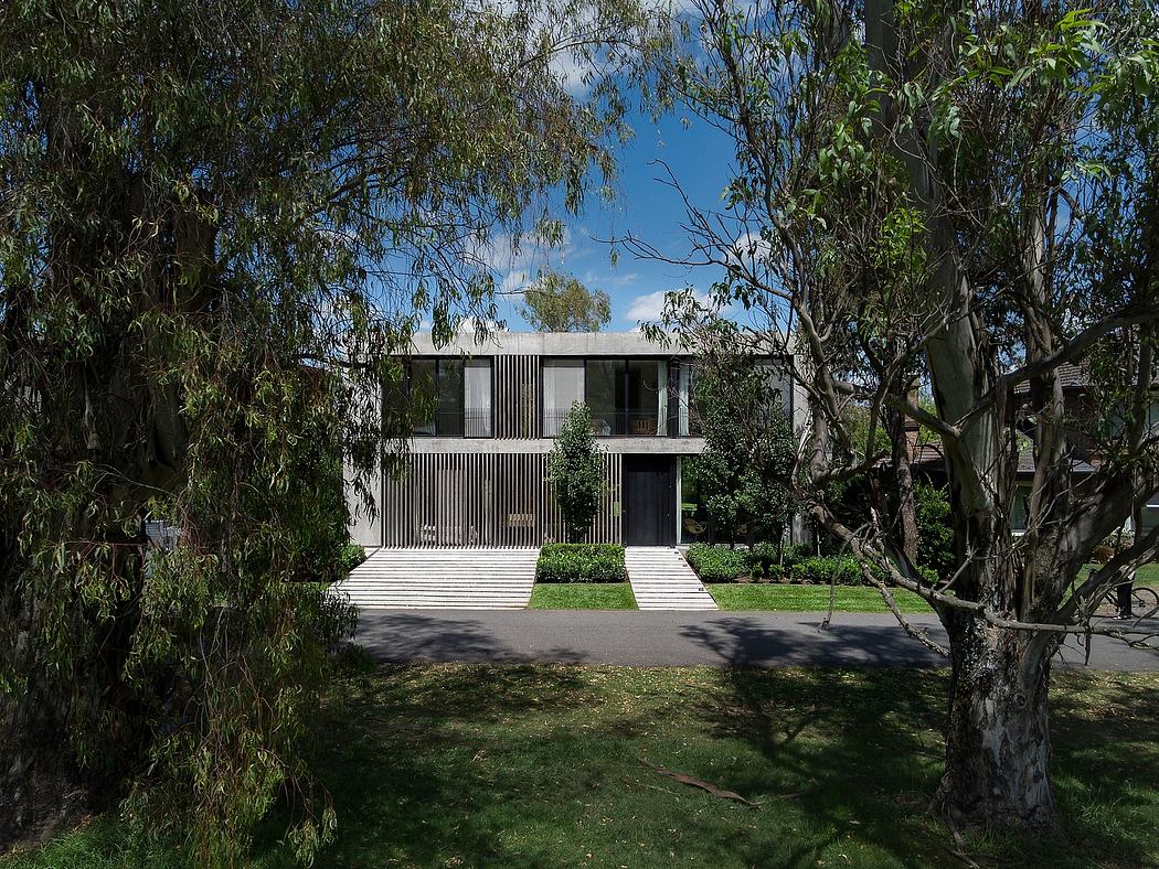 Striking two-story modern home with clean lines, recessed entryway, and lush greenery.