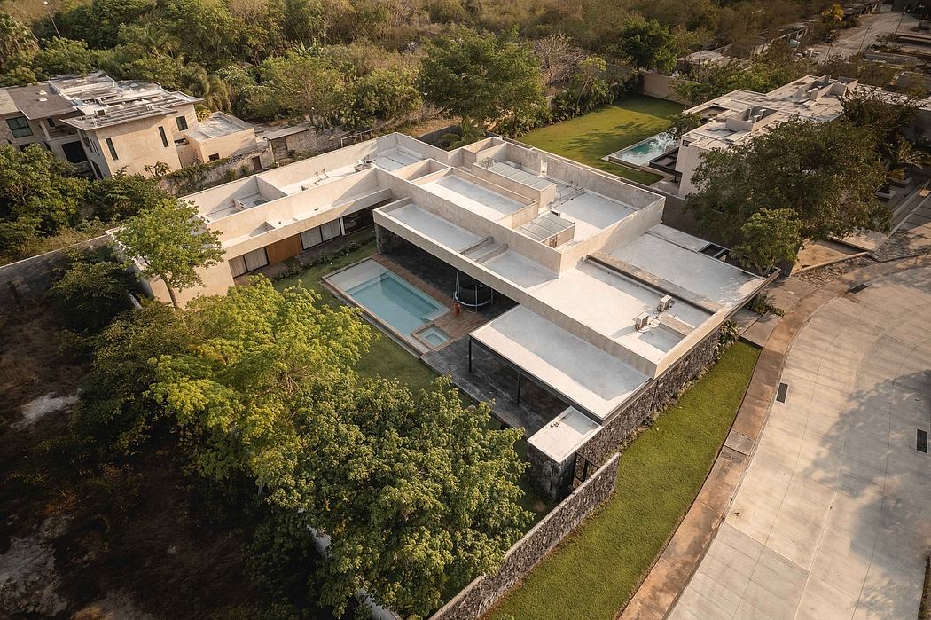 Sprawling modern residence with flat roofs, expansive terraces, and lush landscaping.