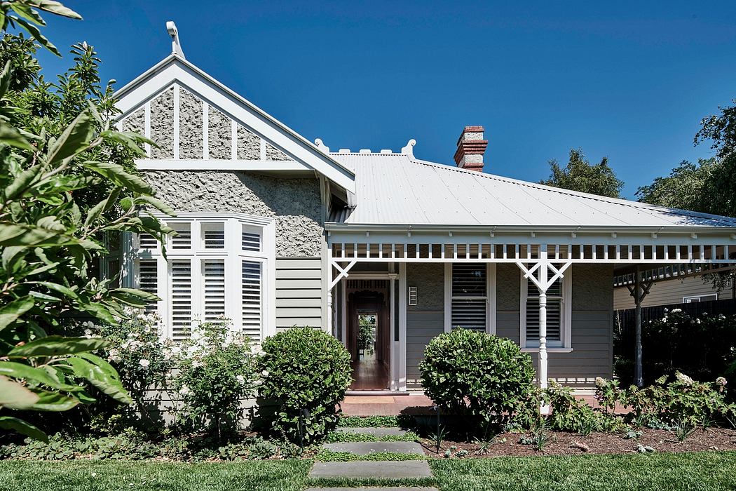 Historic Victorian-style house with a covered porch, tall gabled roof, and decorative woodwork.