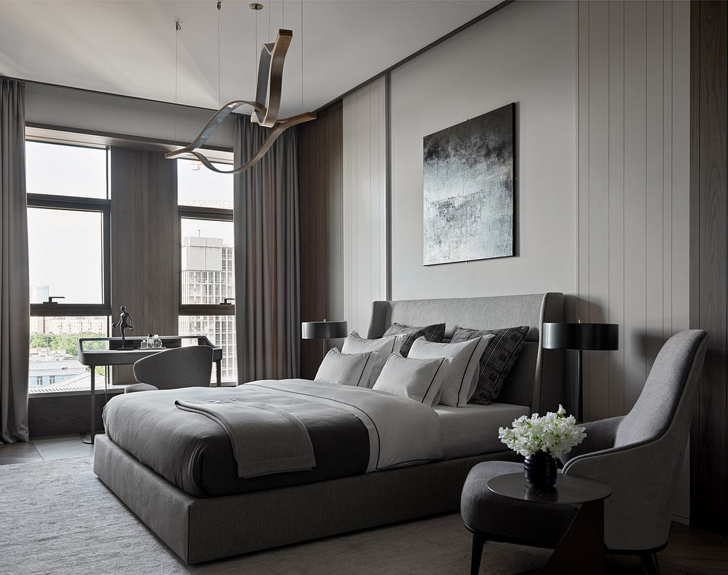 A modern bedroom with a gray-toned color scheme, minimalist decor, and large window offering a cityscape view.