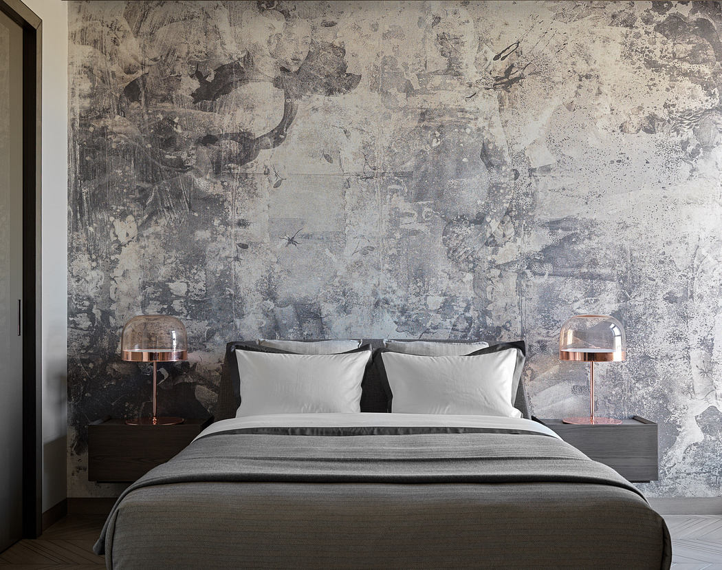 Minimalist bedroom with concrete wall, gray bedding, and copper lamps on nightstands.